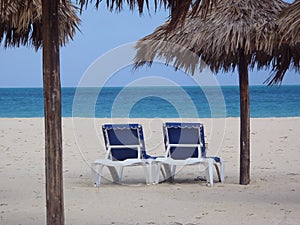 White sandy beach with chairs and cabana