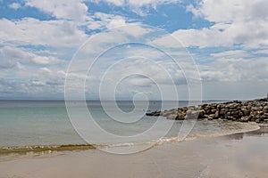 White Sandy Beach Seascape with Clouds and Rocks