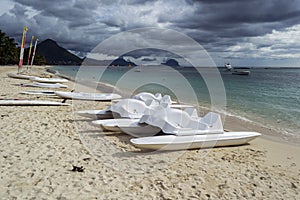 White sandy beach with swings and serpents, dark clouds and mountains