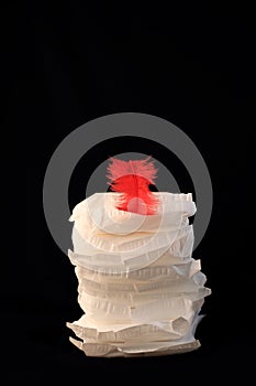 White sanitary individually wrapped napkin pads in stack on black background. Menorrhagia, heavy menstruation bleeding photo