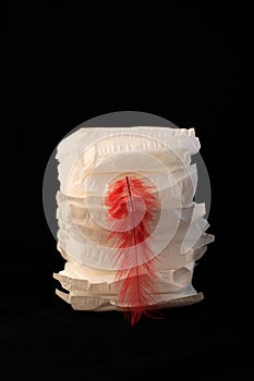 White sanitary individually wrapped napkin pads in stack on black background. Menorrhagia, heavy menstruation bleeding photo