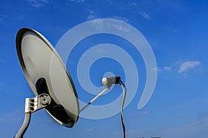 White satellite antenna with blue sky and white clouds background