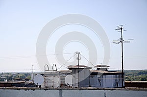 White satellite dishes with two converters mounted on residental building rooftop concrete wall. Satellite television