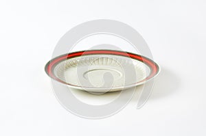 White saucer with red rim