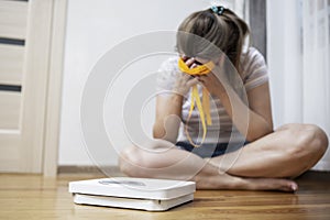 White scale and depression, upset and sad woman with measuring tape on wooden floor