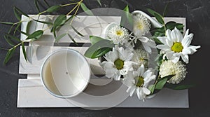 White scented candle and delicate flowers photo