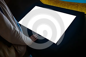 Woman using interactive empty white touchscreen display kiosk at exhibition