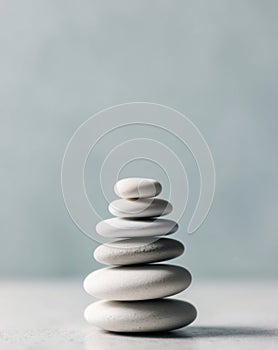 White sea pebble stone stack on light blue background.