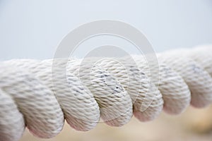 White sea rope close-up on a wharf in the summer