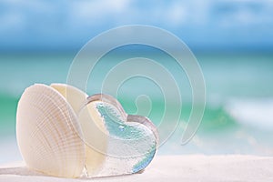 White sea shell with heart glass on beach and sea blue backgrou