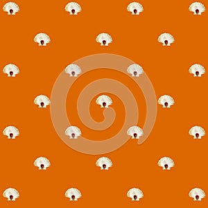 White seashell and small red ball over marigold backdrop. Abstract isometric pattern.
