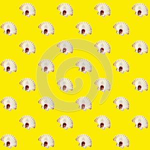 White seashell and small red ball over yellow backdrop. Abstract isometric pattern.