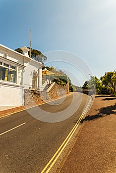 White seaside building on a hill, along an asphalt road, exotic