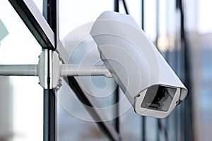 White security cctv camera on glass facade