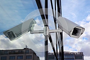 White security cctv camera on glass wall