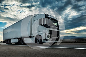 White semi trailer lorry truck on a highway at sunset