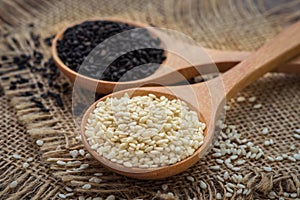 White sesame and black sesame seed on wooden spoon