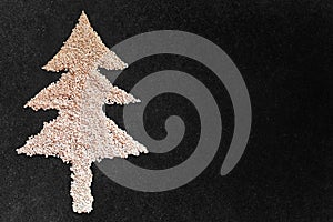 White sesame seed christmas Tree designed on black granite texture background with blank space. Top View