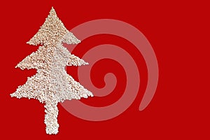 White sesame seed christmas Tree designed on red background with blank space. Top View. christmas