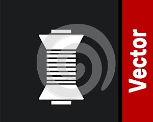 White Sewing thread on spool icon isolated on black background. Yarn spool. Thread bobbin. Vector Illustration