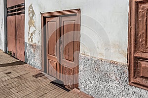 White shabby wall and old wooden doors of a building in Santa Cruz de Tenerife