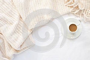 White sheets and cream blanket flatlay with espresso