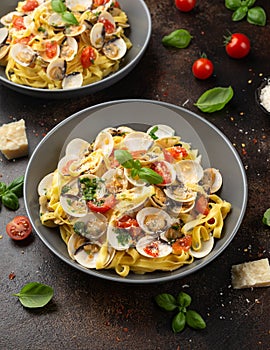 White shell clams in Garlic and parsley white wine sauce tagliatelle pasta served with cherry tomatoes and parmesan