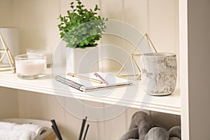 White shelving unit with notebook and decorative stuff, closeup