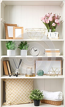 White shelving unit with plants and decorative stuff