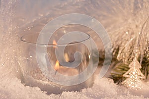 White shining decorations with a candle on the christmas tree.