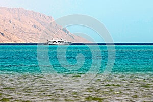 White ship in blue sea on mountain background in Red Sea