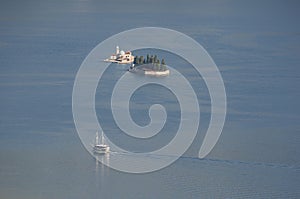 White ship close to two small islands in Adriatic sea