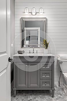 White shiplap bathroom with a grey vanity. photo