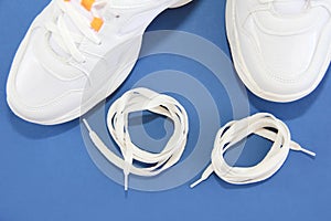 White shoe laces and sports shoes sneakers on a blue background