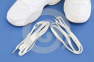 White shoe laces and sports shoes sneakers on a blue background