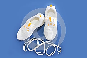 White shoe laces and sports shoes sneakers on a blue background