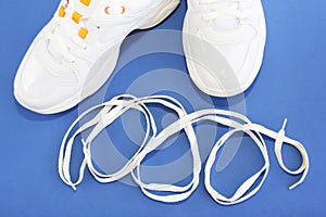 White shoe laces and sports shoes sneakers on a blue background