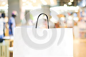 White shopping bag over blurred store background