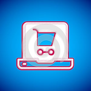 White Shopping cart on screen laptop icon isolated on blue background. Concept e-commerce, e-business, online business