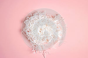 White shredded paper, packaging filler on pink background