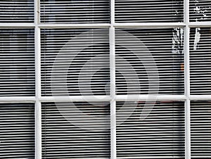 White shutters behind white windows. Simple style of old buildings