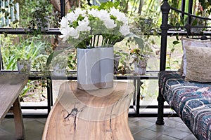 white siam tulip flower in vase on wood table in living room near garden. decoration and interior