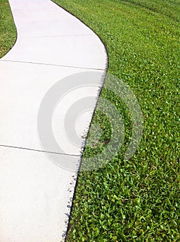 White Sidewalk Edged with Grass