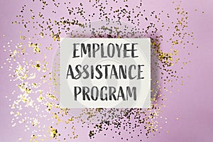 A white sign with gold glitter on it that says Employee Assistance Program