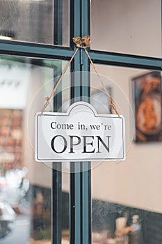 White sign OPEN hanging in cafe front door