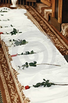 White silk textile at aisle with red roses, decor in church at w