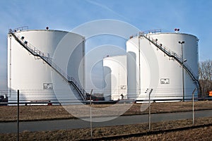 White silo tanks in a tank farm with blue sky