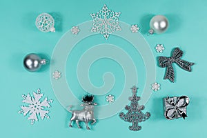 White and silver Christmas decorations on a blue background, top view, flat lay. Christmas mood. Place for an