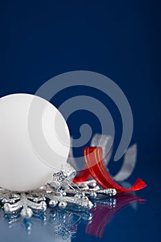 White, silver and red christmas ornaments on dark blue background