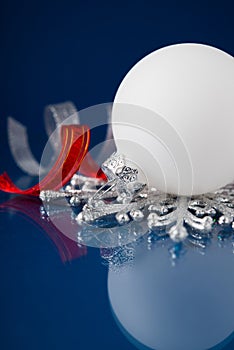 White, silver and red christmas ornaments on dark blue background